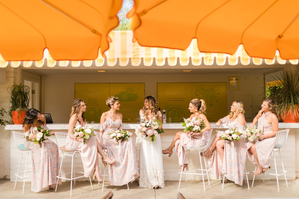 bride and wedding party posed at Parker Palm Springs colorful outdoor bar